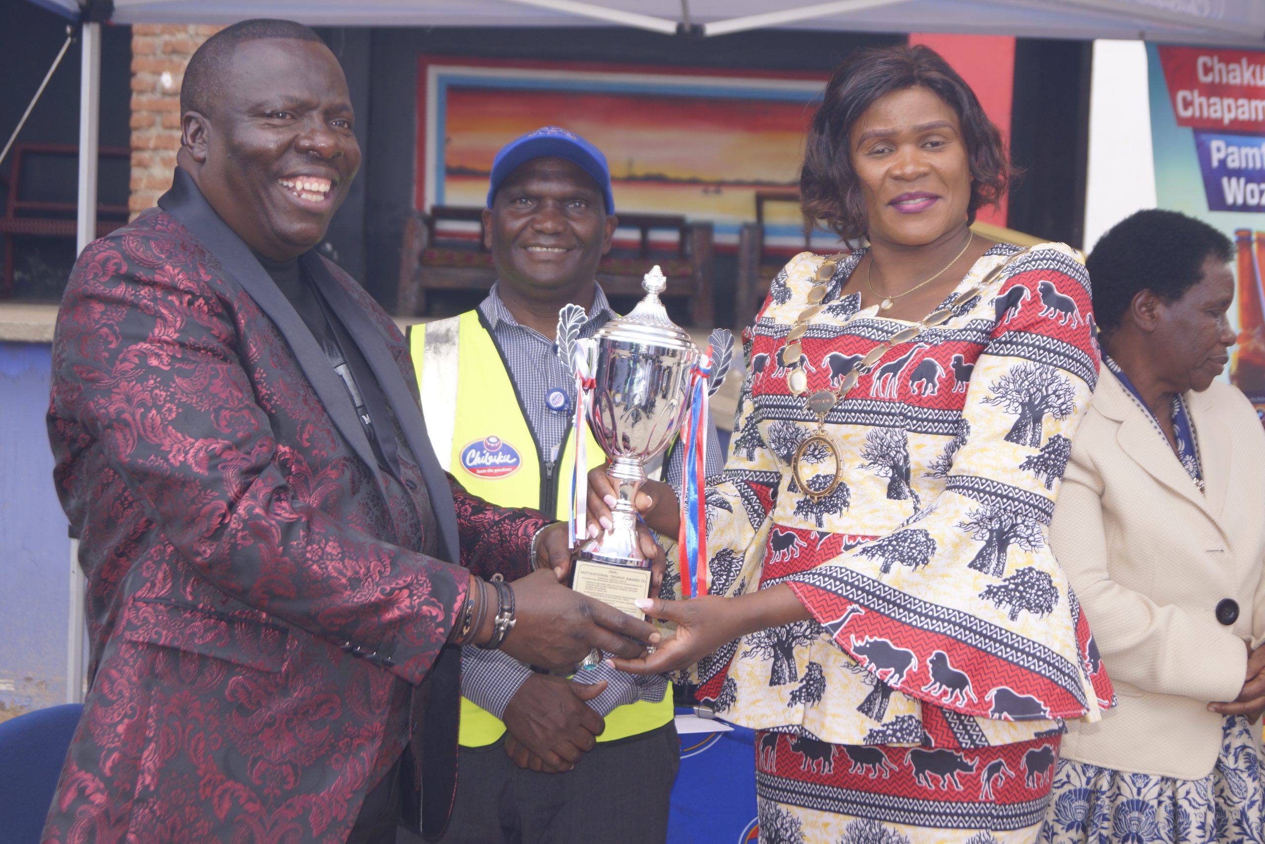 Councillor Ruth Chingwalu-Njirayafa (right) presenting a trophy to Manda as CPL Operations Manager Barter Chunga smiles in the background | Photo by Watipaso Mzungu in Lilongwe
