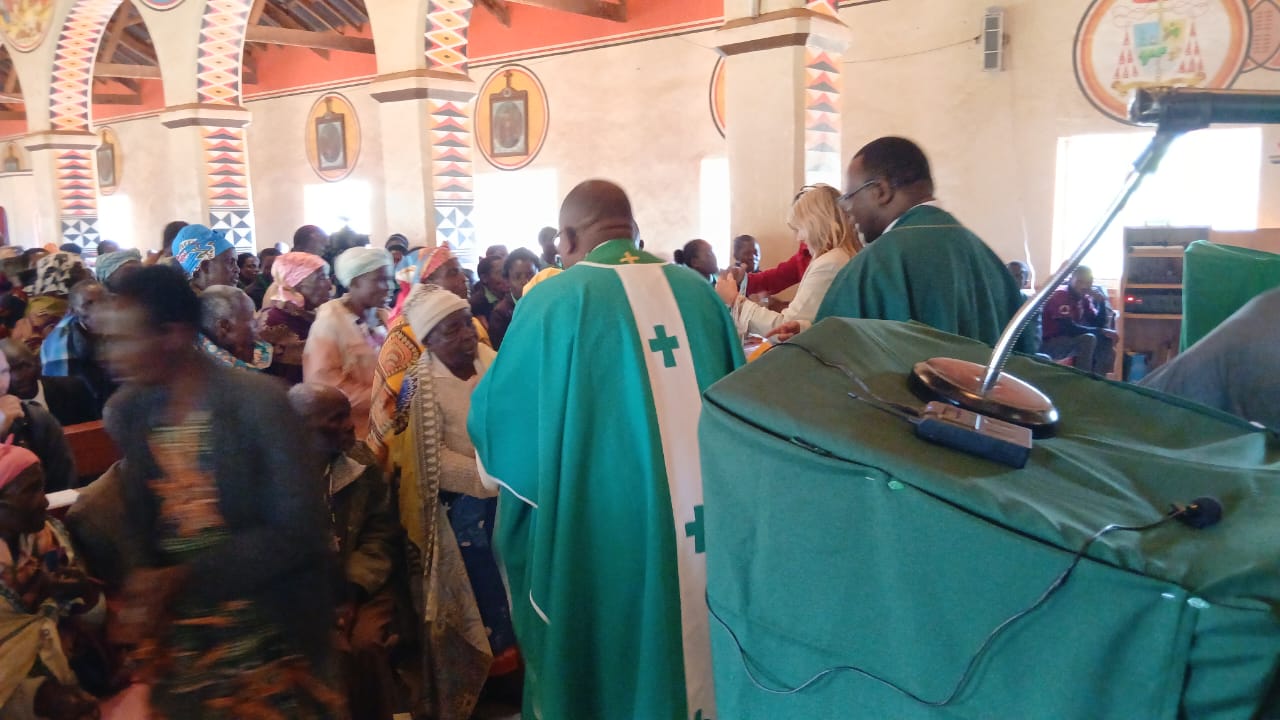 Father Sikwese and other priests presenting gifts to grandparents and the elderly after the homily
